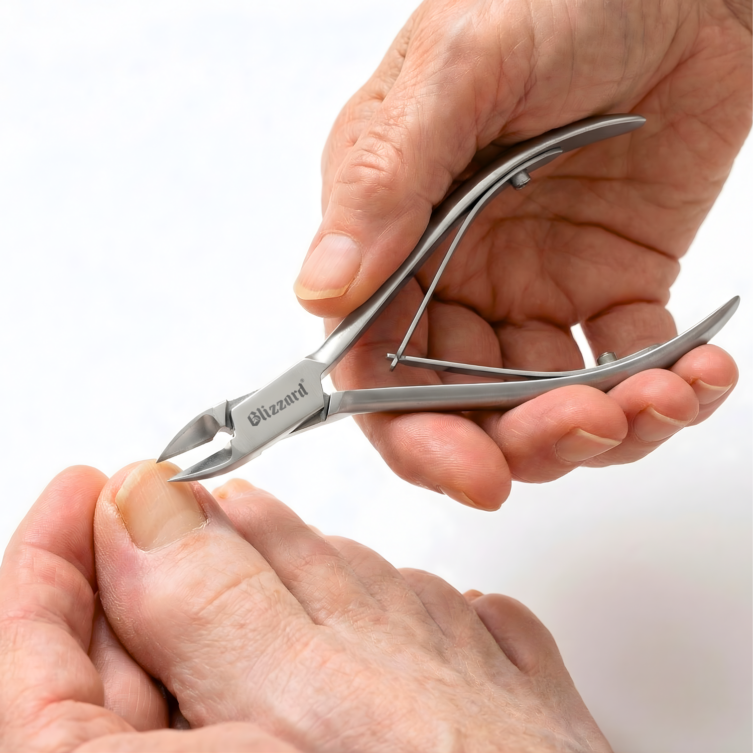 Person using a pair of nail clippers on a white background