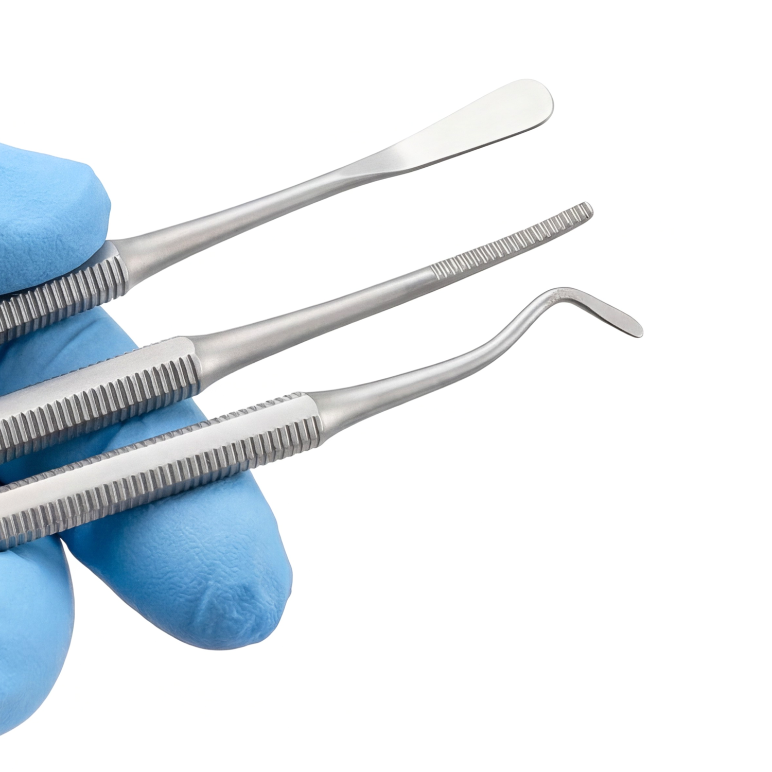 Set of dental tools held by a gloved hand on a white background