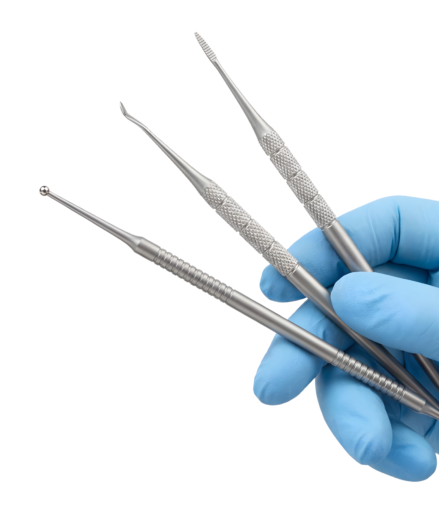Set of dental tools held by a gloved hand on a white background
