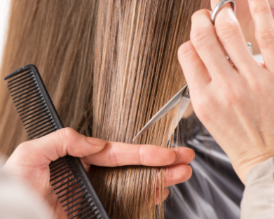 Person cutting hair with scissors and a comb